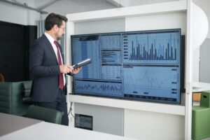 Man standing and examining a board of graphs